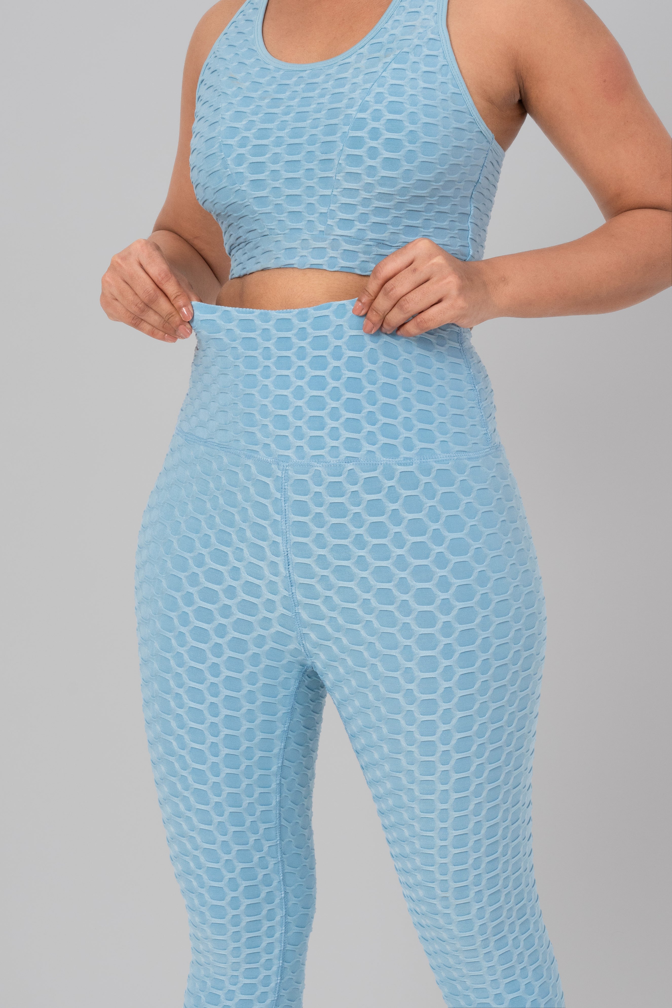 Woman in workout leggings, Sky Blue - Waist Band pull stretch demonstrating stretchable and breathable fabric.@@@color_Sky-Blue