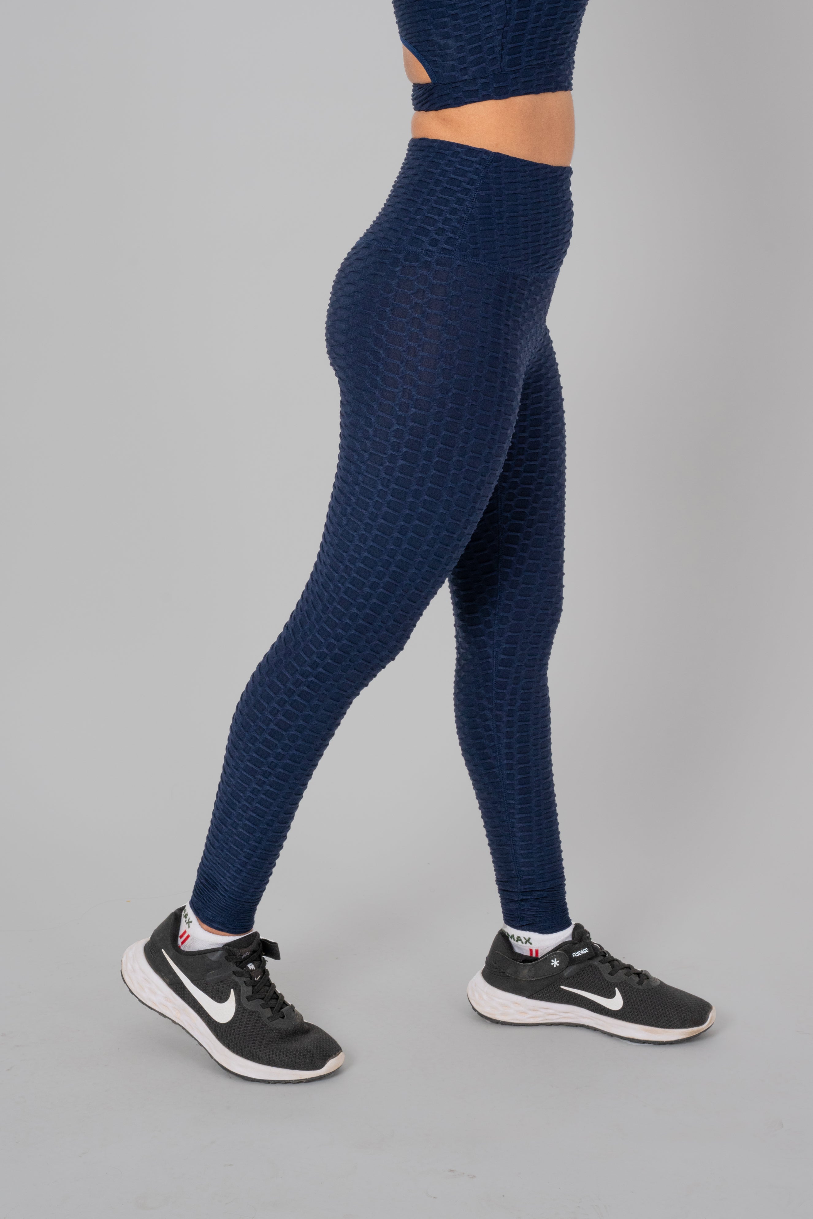 Woman in workout leggings, Navy Blue- side walking pose emphasizing medium compression and squat proof design.@@@color_navy-blue