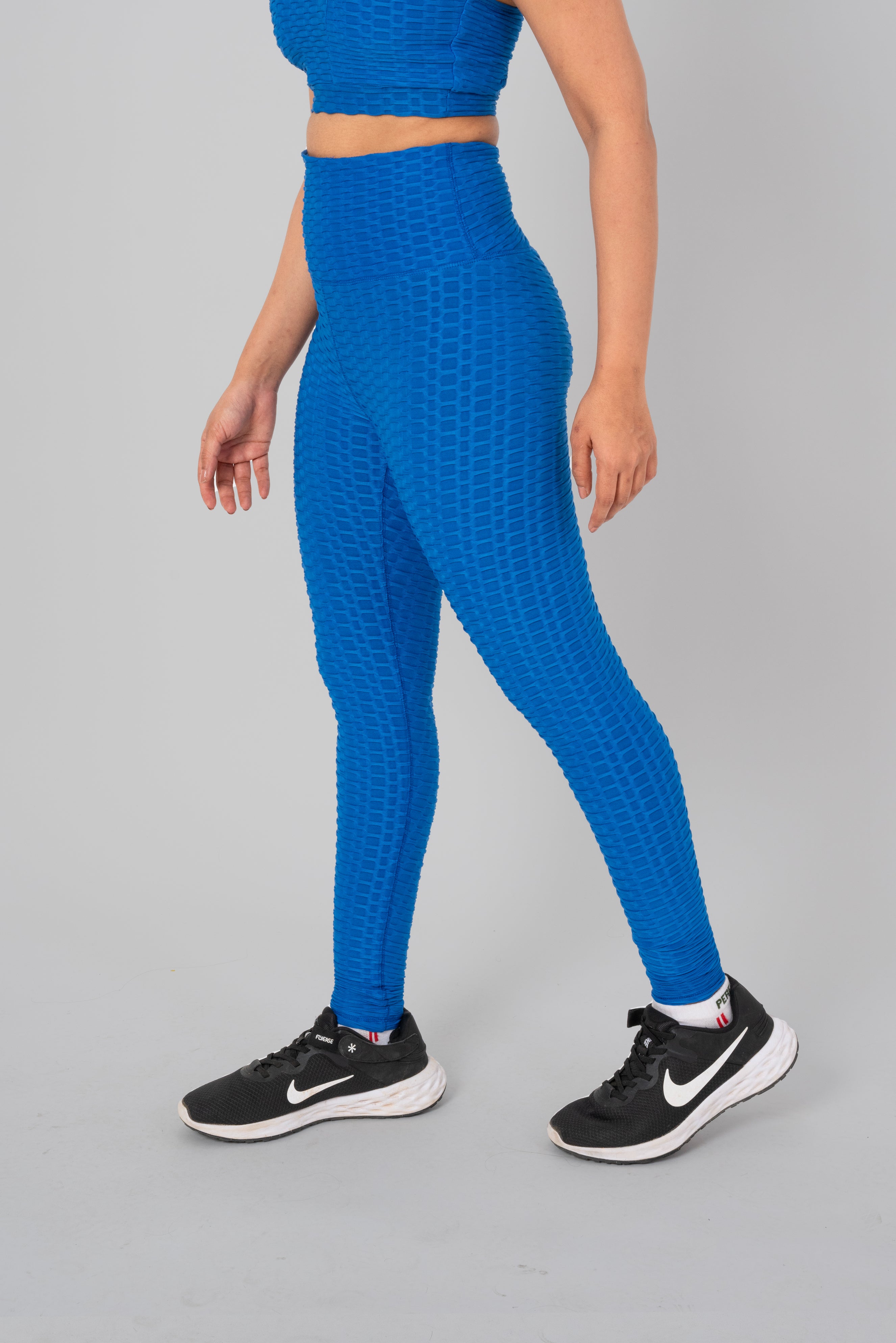 Woman in workout leggings,  Teal Blue- side walking pose emphasizing medium compression and squat proof design.@@@color_Teal-Blue