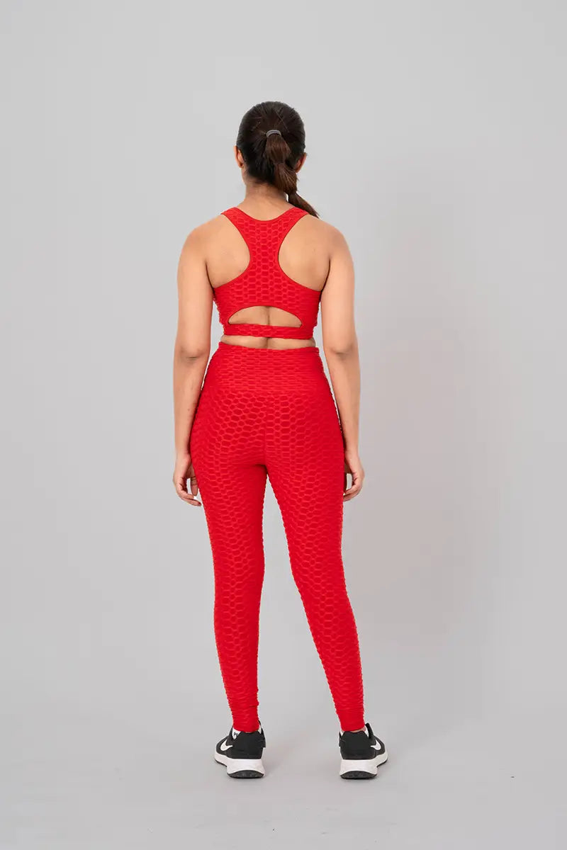 Woman in gym clothes coord set, red - back view showing open back keyhole design and 4-way compression fabric.