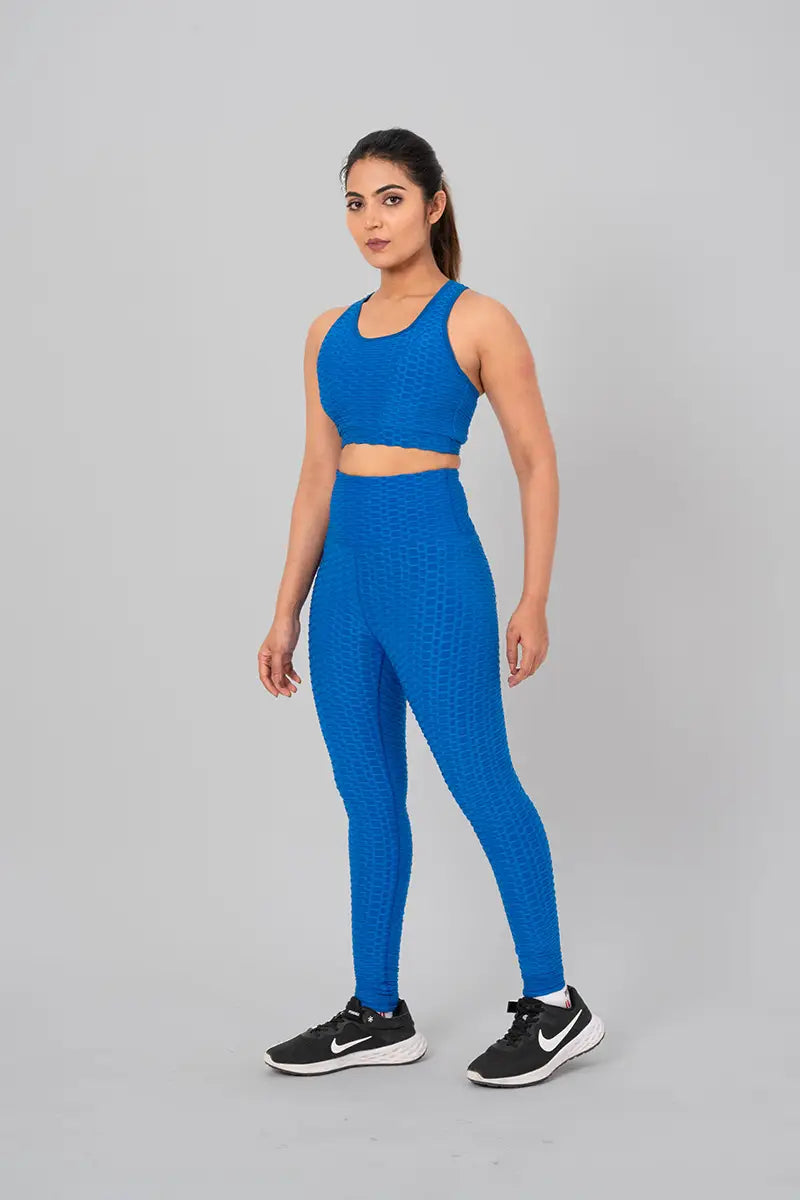 Woman in gym outfits, teal blue coord set - relaxed standing pose showcasing breathable fabric and moisture-wicking technology.