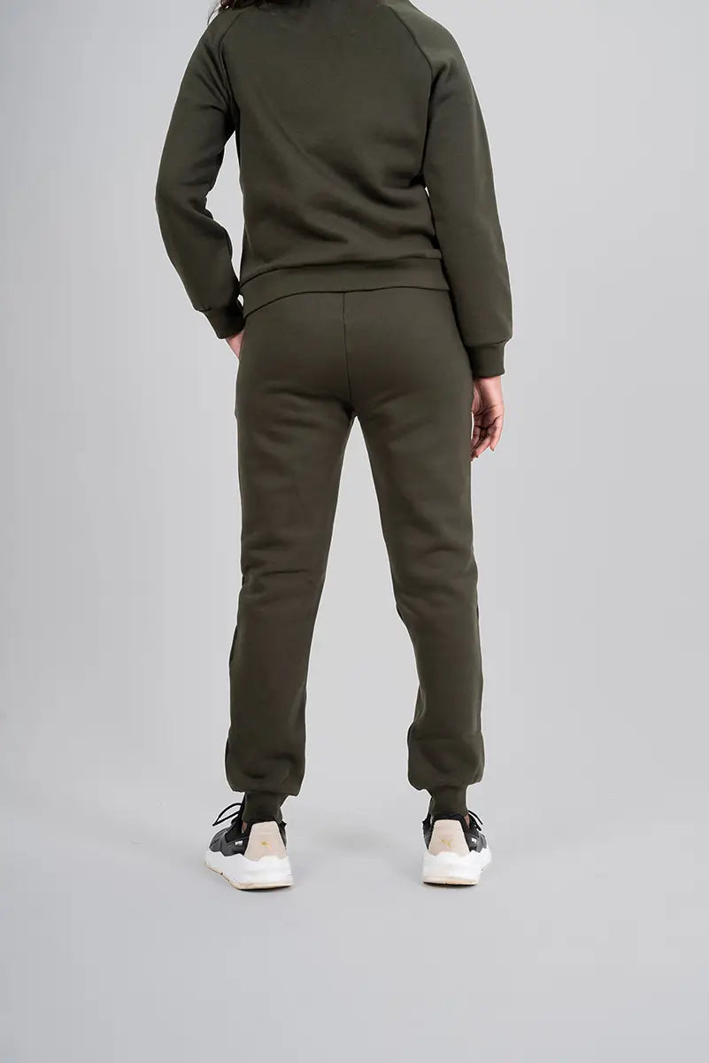 Woman in gym pants, olive jogger - back view with hands on waist highlighting relaxed style and cozy material.