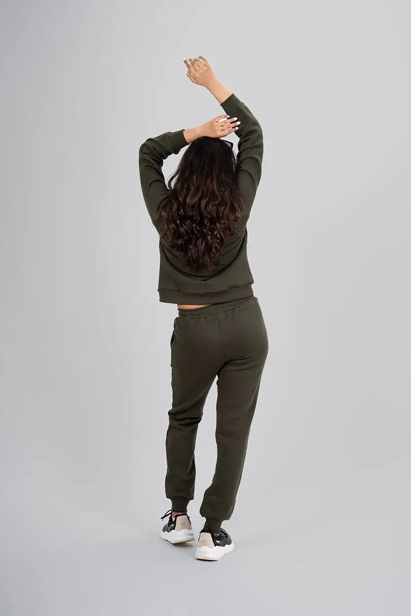 Woman in gym pants, olive jogger - back view with arms stretched up, showing full coverage and comfortable design.