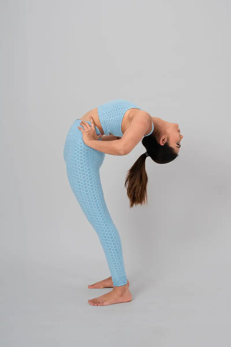 Woman in gym wear sets, sky blue coord set - back stretch pose showing breathable fabric and moisture-wicking properties.