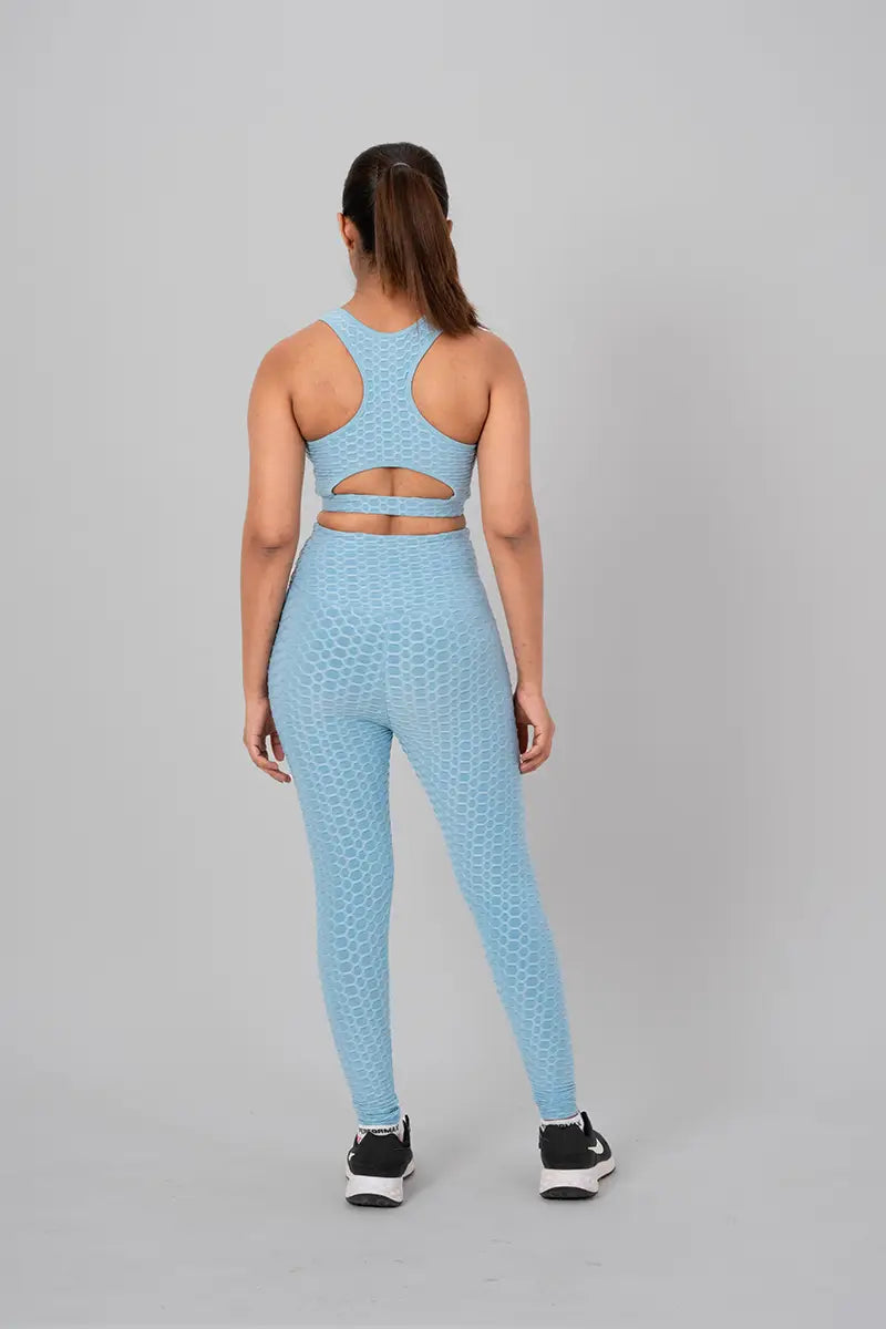 Woman in gym wear sets, sky blue coord set - back view standing showing open back keyhole design and medium support.