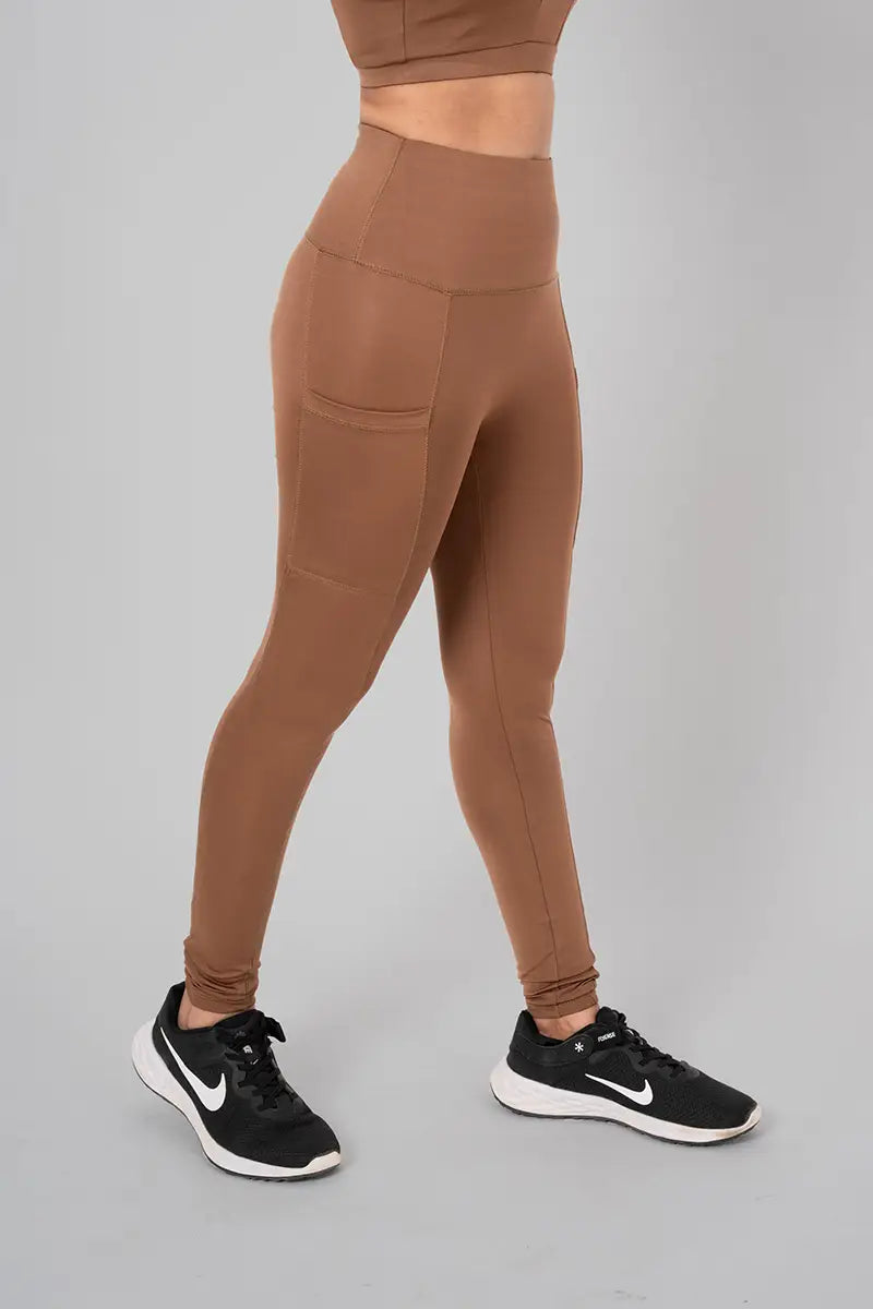 Woman in leggings with pockets, front view showing high-waisted fit and breathable, sweat-wicking fabric. @@@color_cocoa