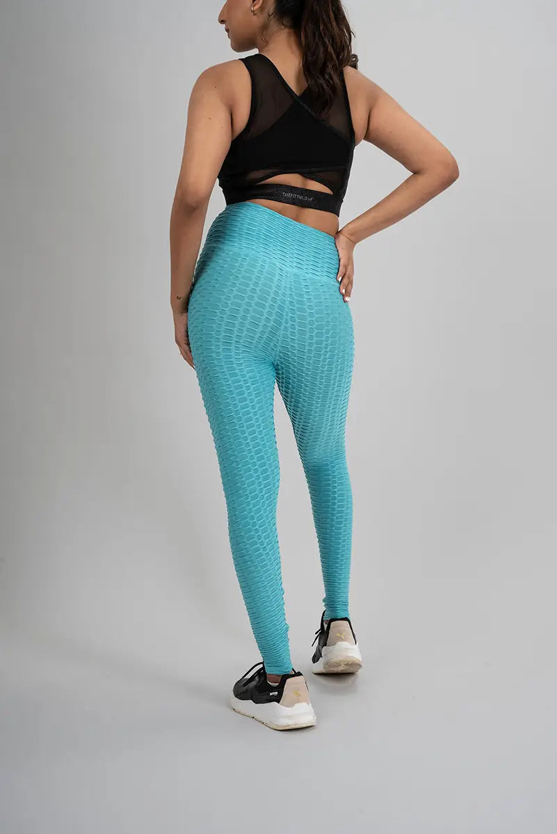 Woman in high waisted leggings, aqua blue - back view showing breathable and sweat-wicking honeycomb fabric.