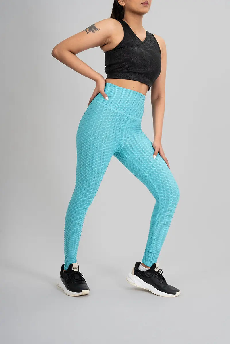 Woman in high waisted leggings, aqua blue - side stretch pose showing breathable and squat proof fabric.