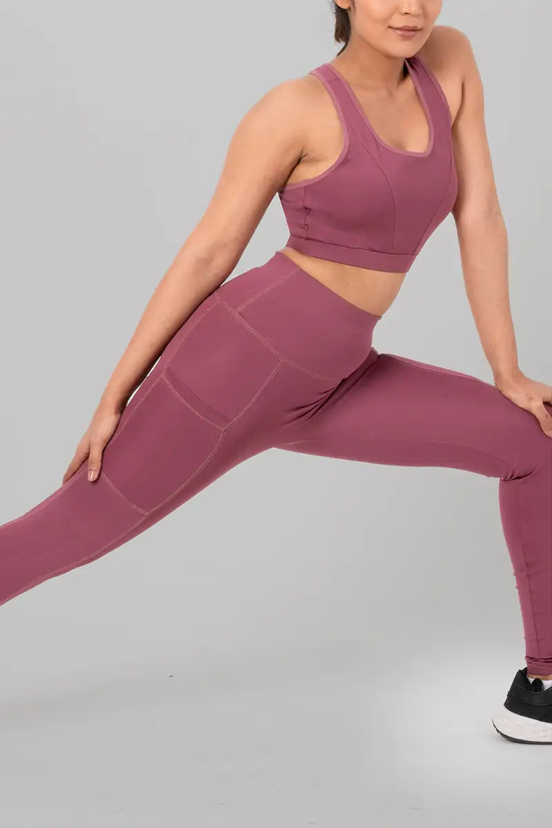 Woman in tights working-out, black - side lunge pose demonstrating flexibility and stretchable material.