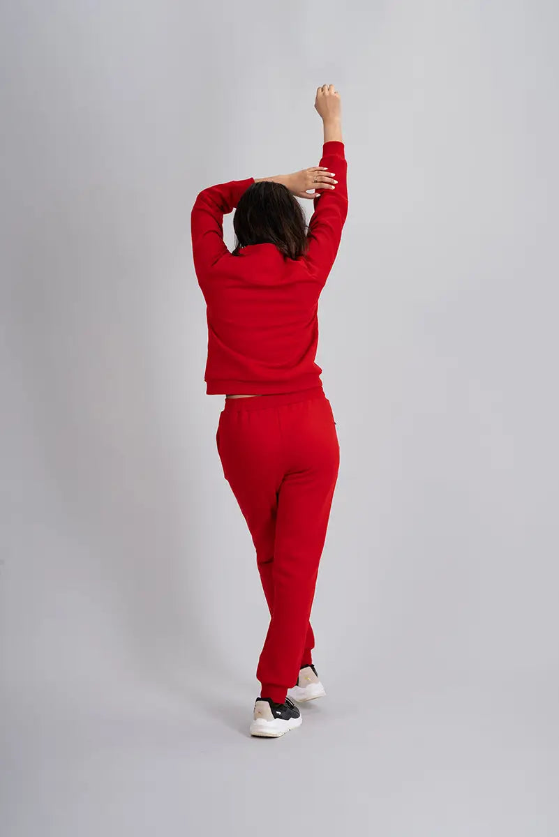 Winter tracks for women, red jogger - back view with arms raised, showing full coverage and comfortable fit.