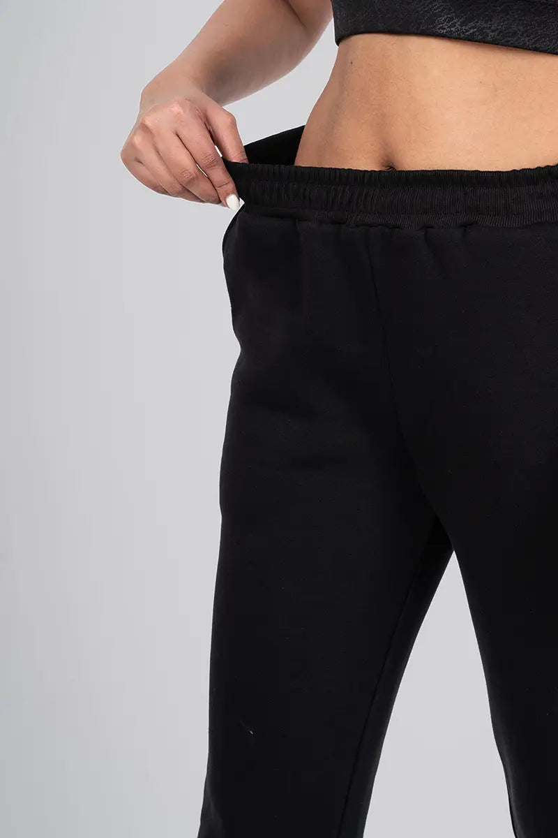 Close-up of waistband on women's gym pants, black jogger - highlighting adjustable waistband and snug fit.