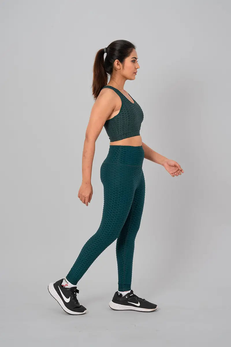 Woman in womens gym wear, bottle green coord set - side stretch pose showing high-waisted fit and moisture-wicking properties.