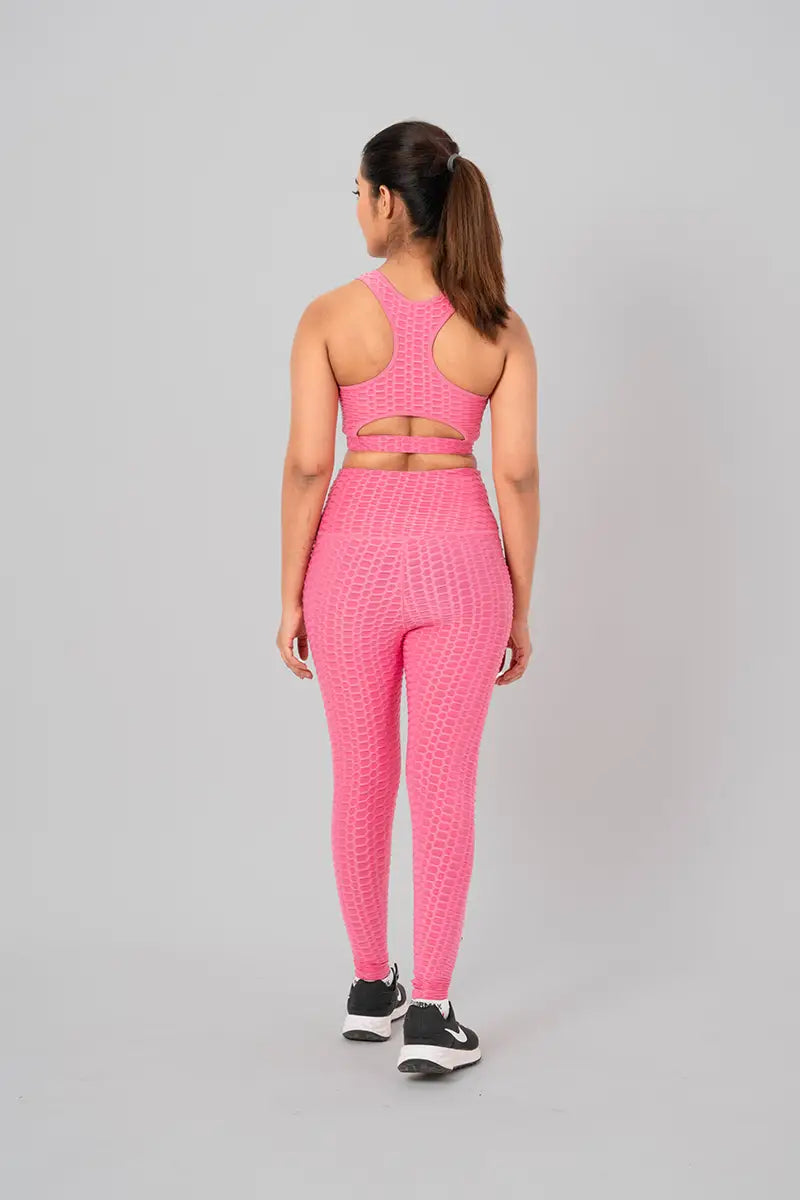 Woman in workout clothes, pink coord set - back view showing open back keyhole design and medium support.