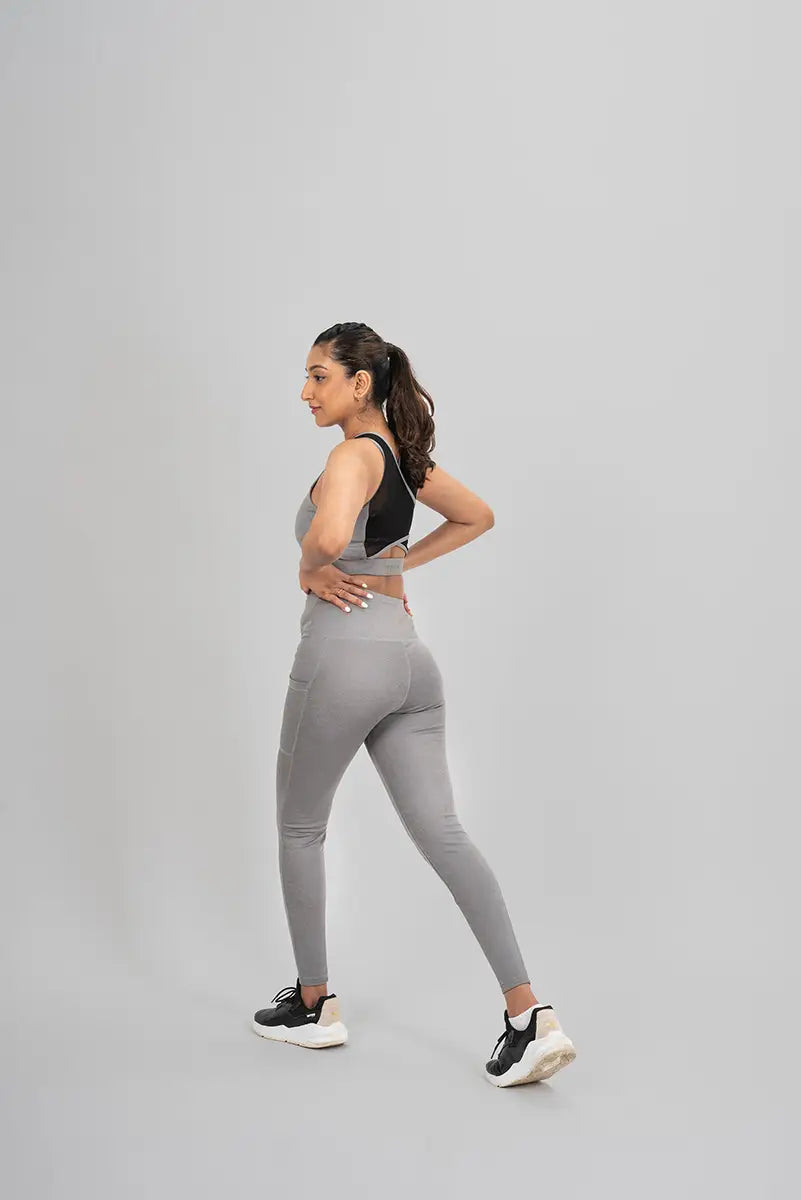 Woman in workout leggings, grey metallic - side walking pose showing flexibility and squat-proof material.